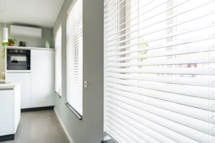 Een witte houten jaloezie in de keuken