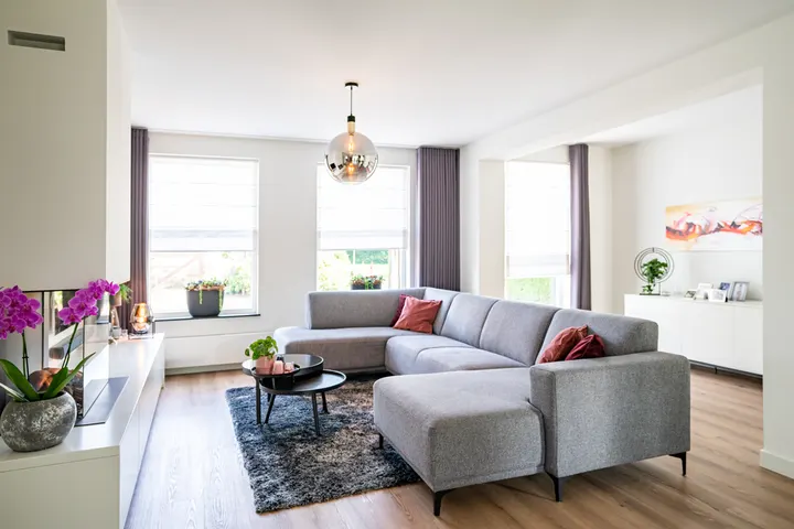 Woonkamer met overgordijnen en transparante vouwgordijnen