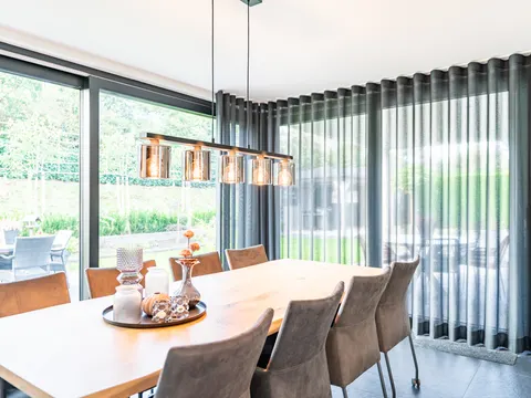 Blauwgrijze inbetween langs de glazen hoek van de eetkamer