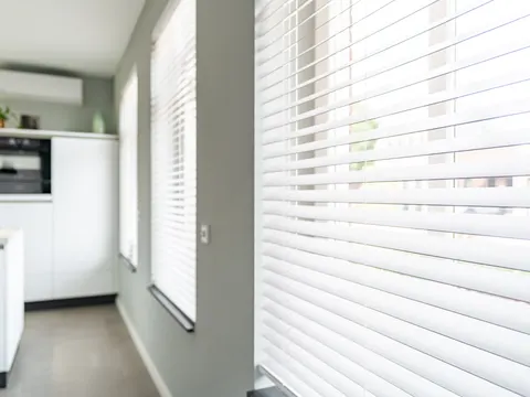 Een witte houten jaloezie in de keuken
