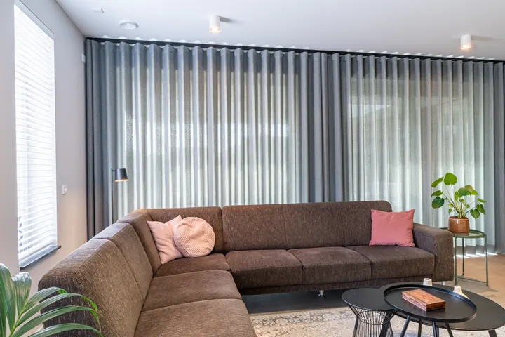 Een hele wand grijsgroene inbetween achter de hoekbank